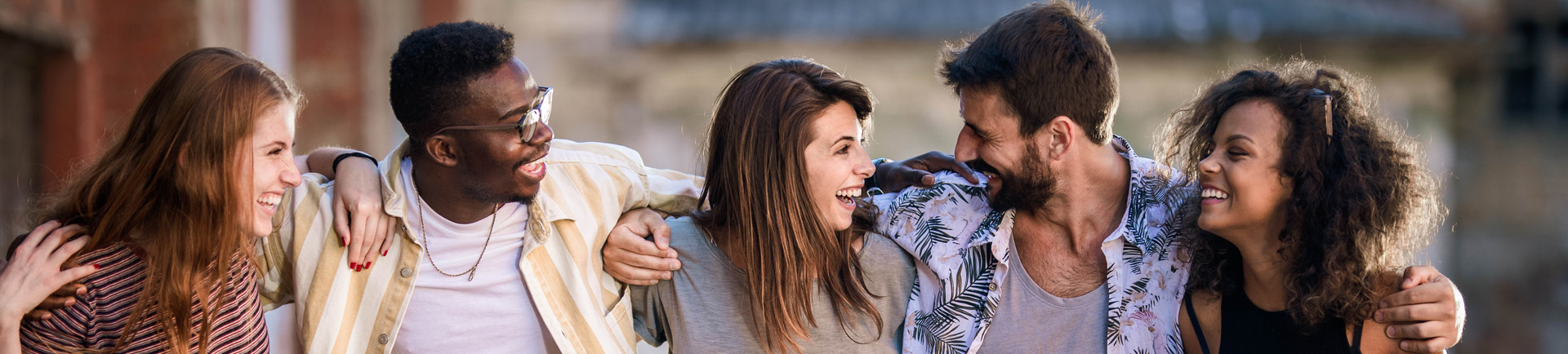 cinco jovens (rapazes e raparigas) abraçados
